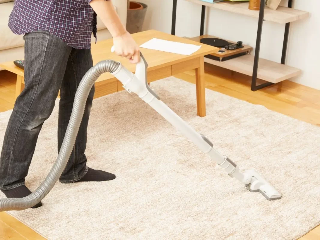 Person Vacuuming a Living Room Carpet